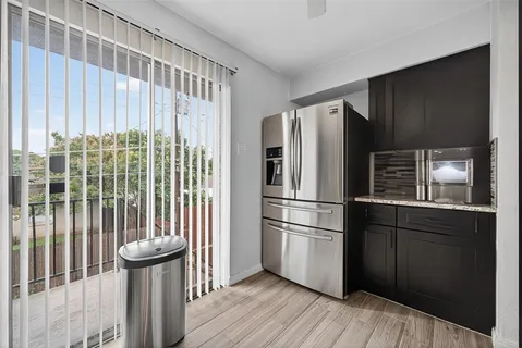 a kitchen with a refrigerator and wooden floor
