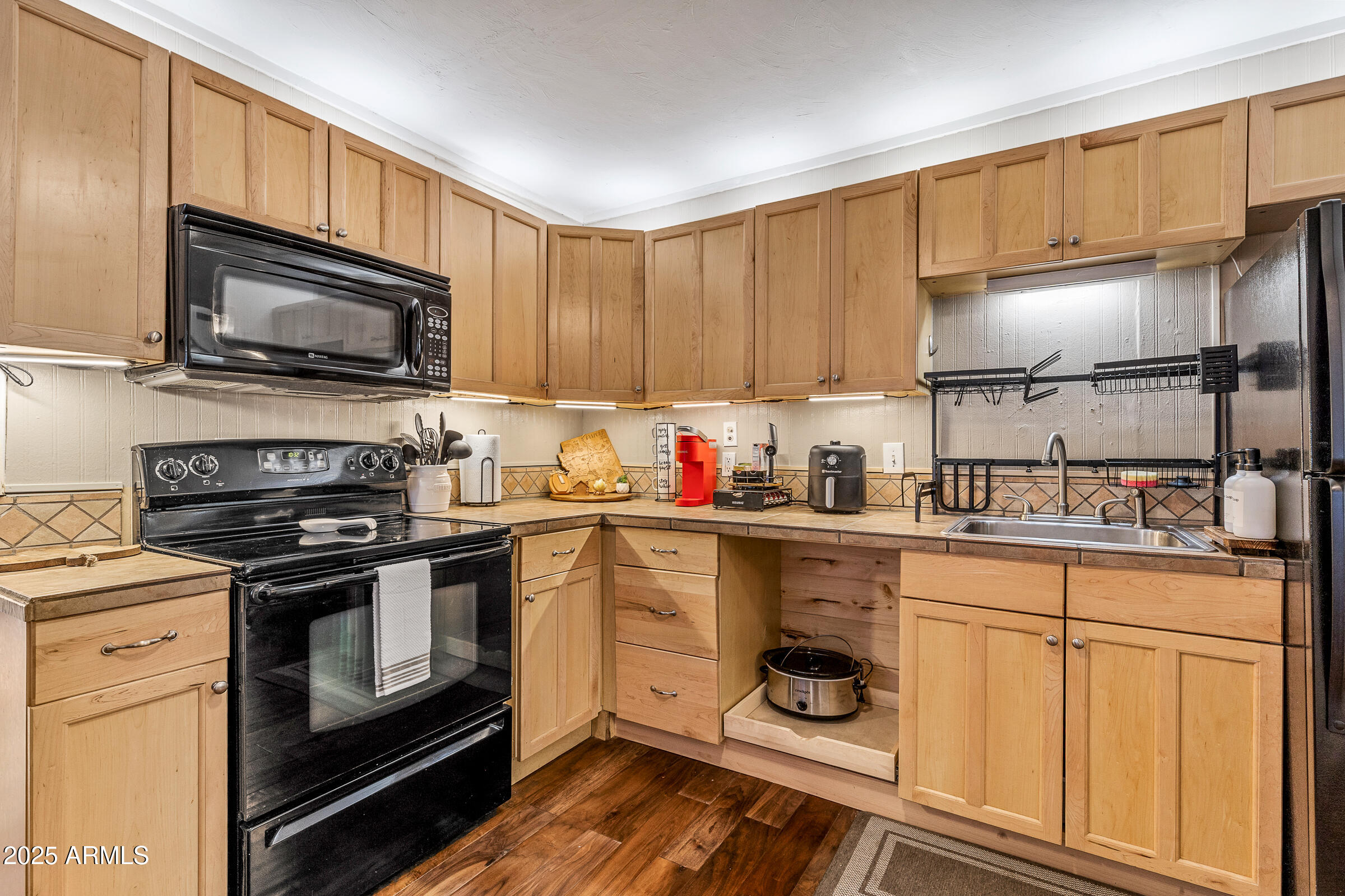 1159 Coyote Road Munds Park, AZ 86017 - Photo 11 of 22 a kitchen with granite countertop wooden cabinets stainless steel appliances and a window