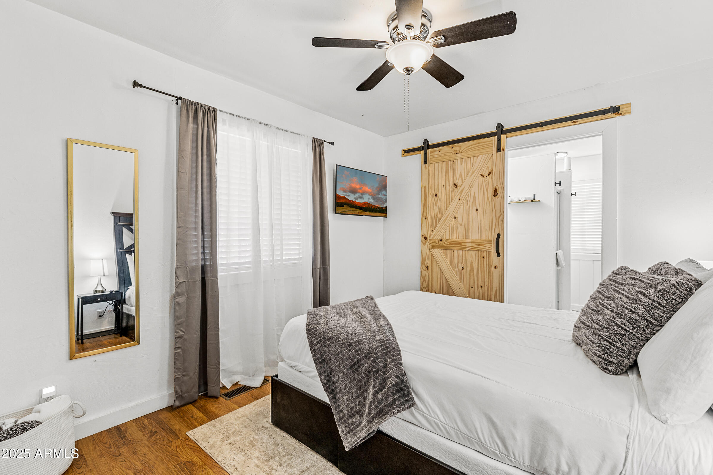 1159 Coyote Road Munds Park, AZ 86017 - Photo 13 of 22 a bedroom with a large bed and a chandelier