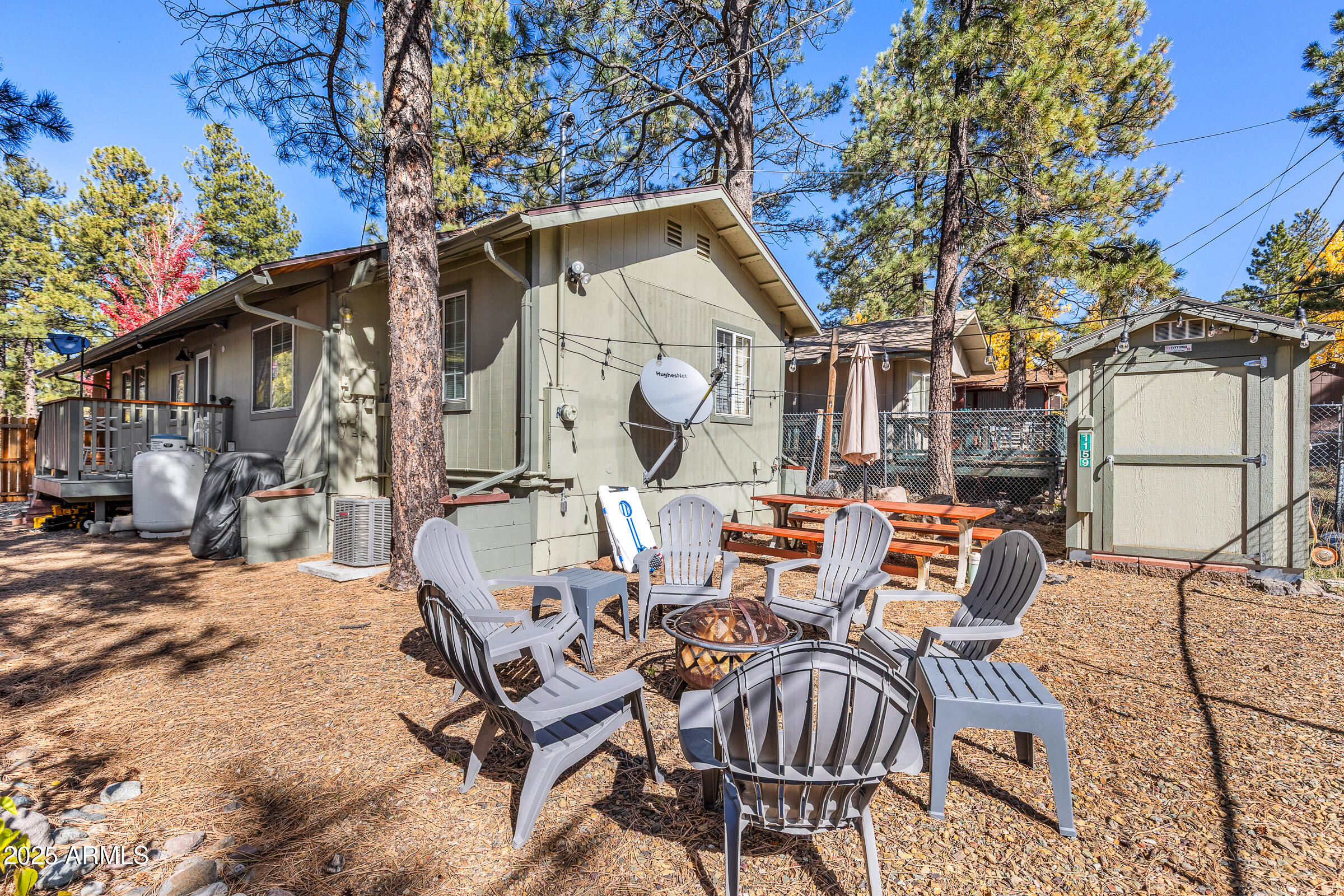 1159 Coyote Road Munds Park, AZ 86017 - Photo 21 of 22 a view of a patio with table and chairs with wooden fence and plants