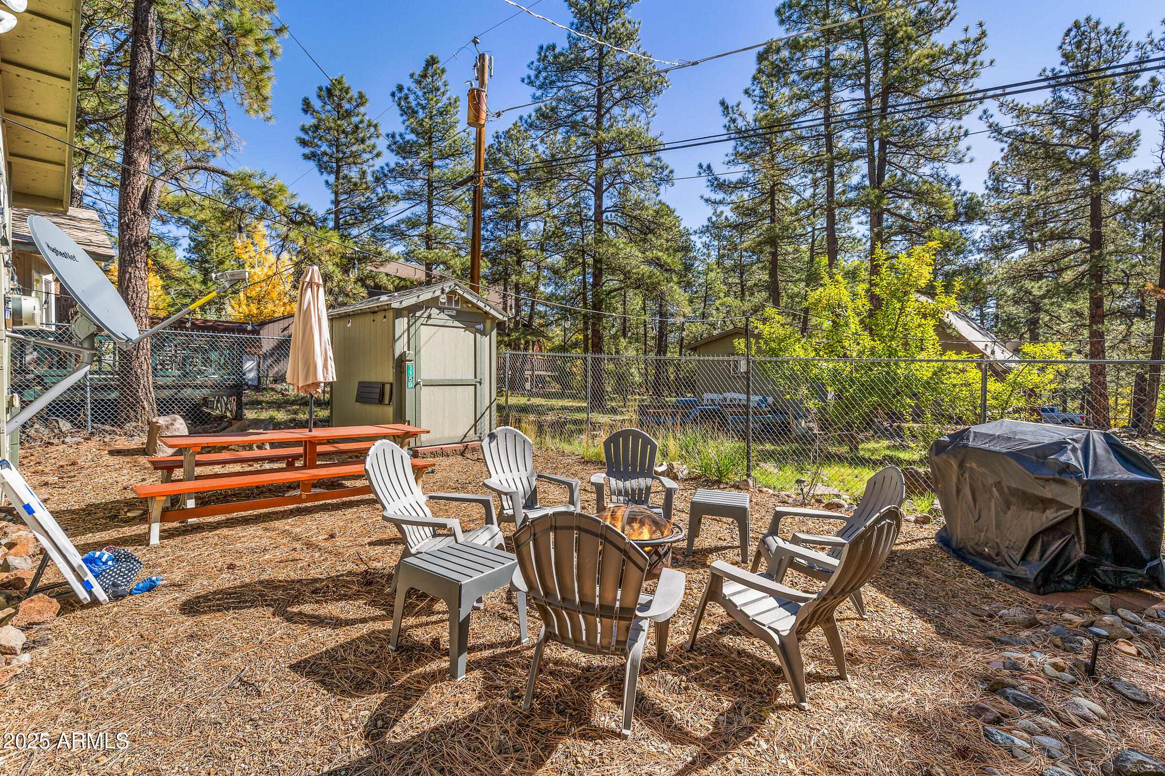 1159 Coyote Road Munds Park, AZ 86017 - Photo 22 of 22 a view of a chairs and table in backyard