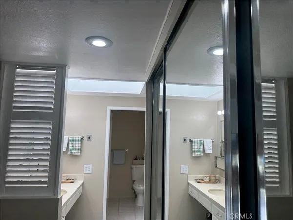 a bathroom with a glass door shower and a sink