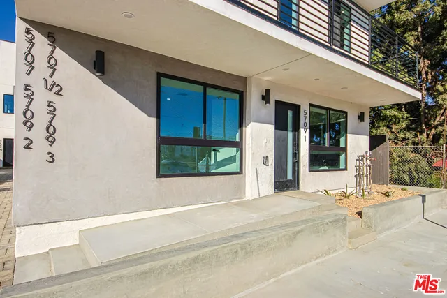 a view of a patio with a table and chairs under an umbrella