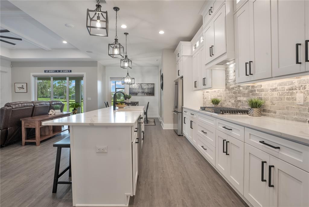 440 Palma Ceia Road Winter Haven, FL 33884 - Photo 13 of 78 a kitchen with kitchen island granite countertop lots of counter top space and wooden floors