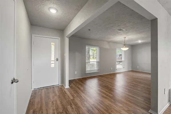 an empty room with window and wooden floor