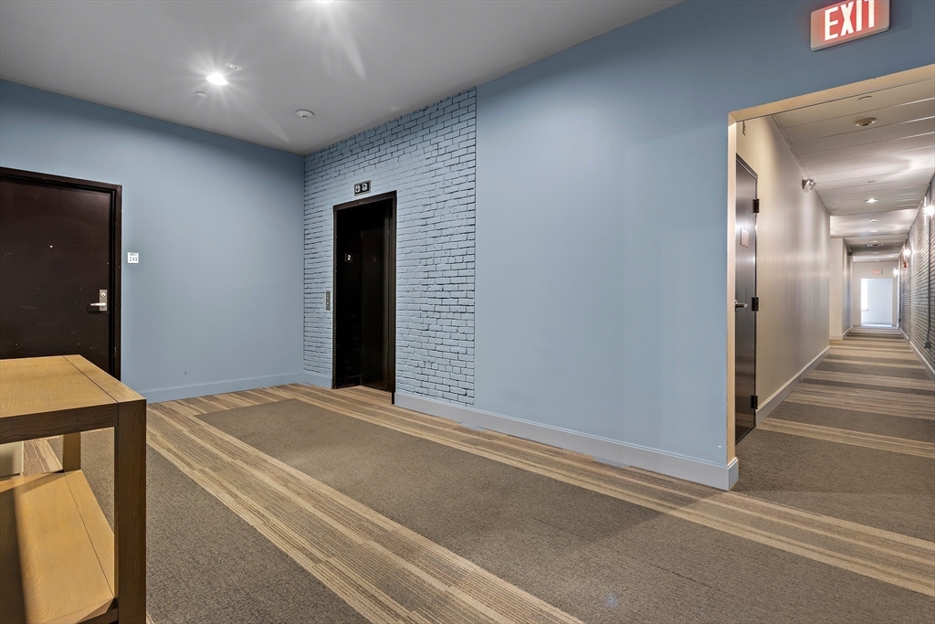 33 3rd Avenue, Unit U214 Boston, MA 02129 - Photo 5 of 17 a view of a hallway with wooden floor and staircase
