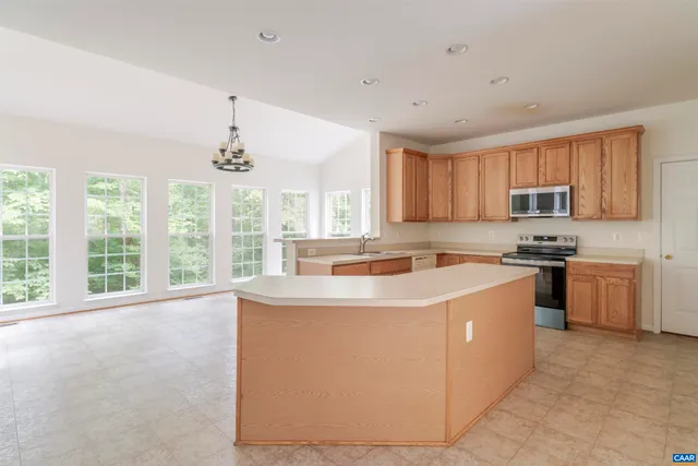 a view of kitchen with stainless steel appliances granite countertop a stove a sink dishwasher and a refrigerator with wooden floor