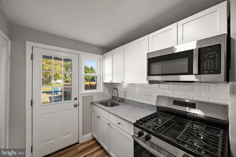 a view of empty room with window and wooden floor