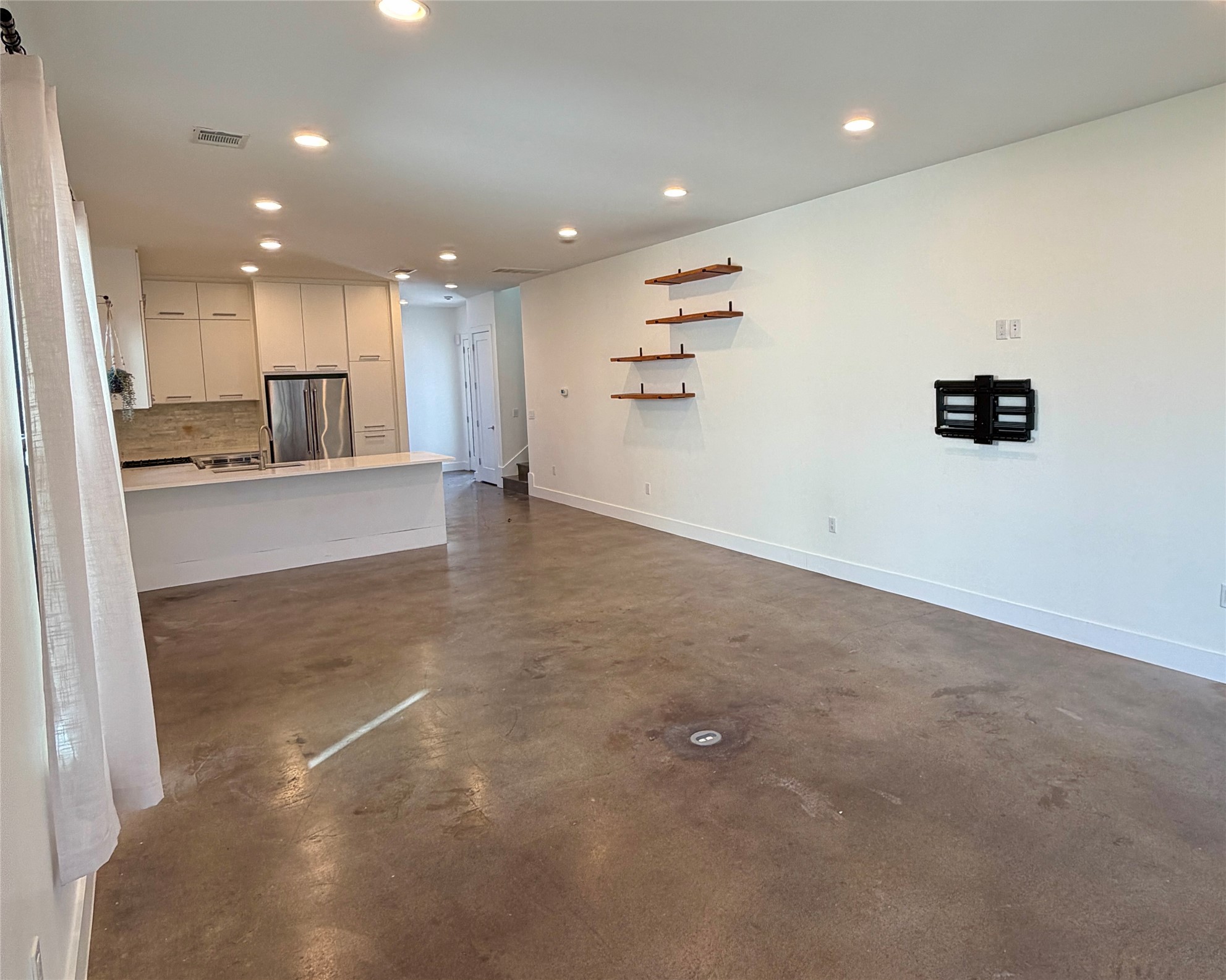 1515 Hether Street, Unit B Austin, TX 78704 - Photo 7 of 30 An open-concept living area with polished concrete flooring seamlessly connects to a modern kitchen.