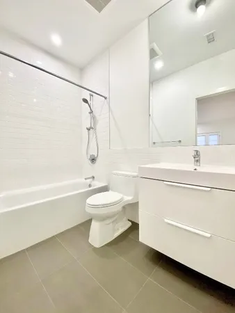 a bathroom with a tub sink vanity and shower