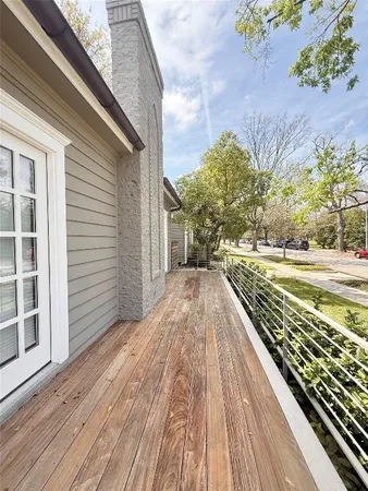 a view of a balcony with wooden floor and fence