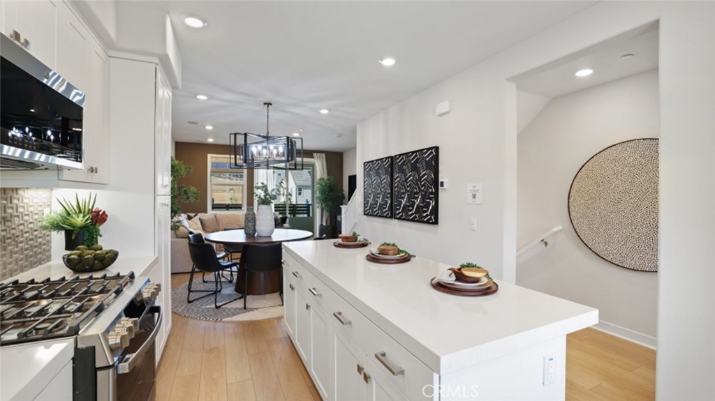 61 Harness Way Rancho Mission Viejo, CA 92694 - Photo 4 of 25 a kitchen with a sink a stove and chairs with wooden floor