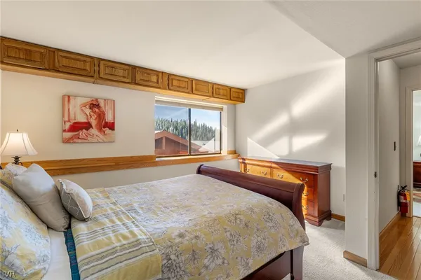 a bedroom with a bed and painting on the wall