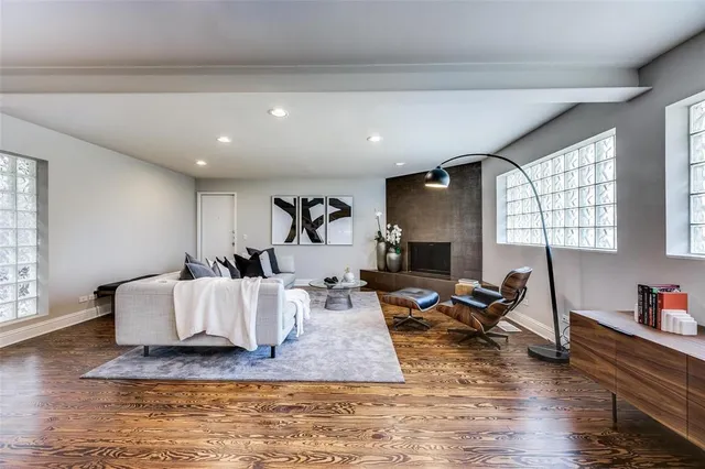 a living room with furniture hard wood floor and a fireplace
