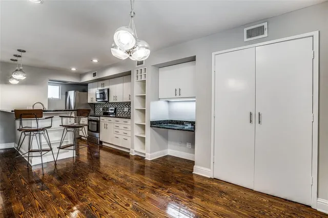 a kitchen with stainless steel appliances a refrigerator and a fireplace