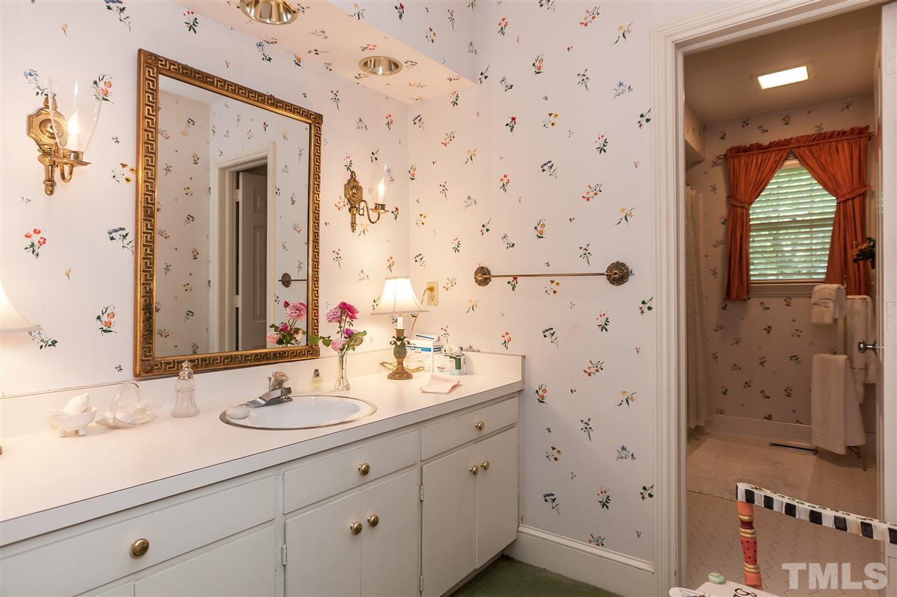 3313 Landor Road Raleigh, NC 27609 - Photo 17 of 25 a bathroom with a sink a mirror and shower