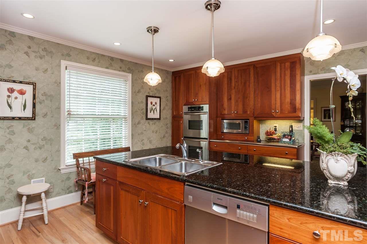3313 Landor Road Raleigh, NC 27609 - Photo 10 of 25 a kitchen with granite countertop a sink a counter space dining table and chairs