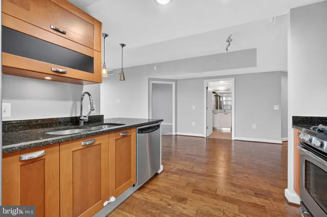 a kitchen with stainless steel appliances granite countertop a sink and a stove