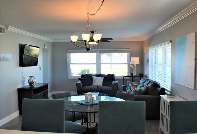a kitchen with kitchen island a dining table chairs stainless steel appliances and cabinets