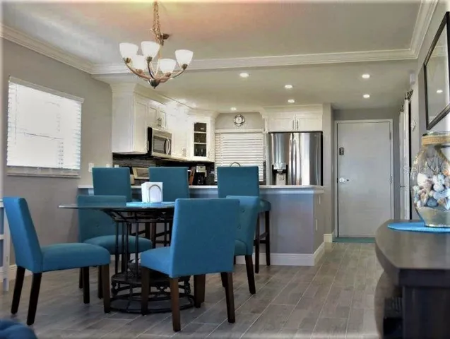 a dining room with furniture a chandelier and wooden floor