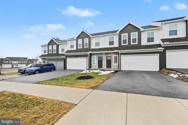 a front view of a house with a garden and parking