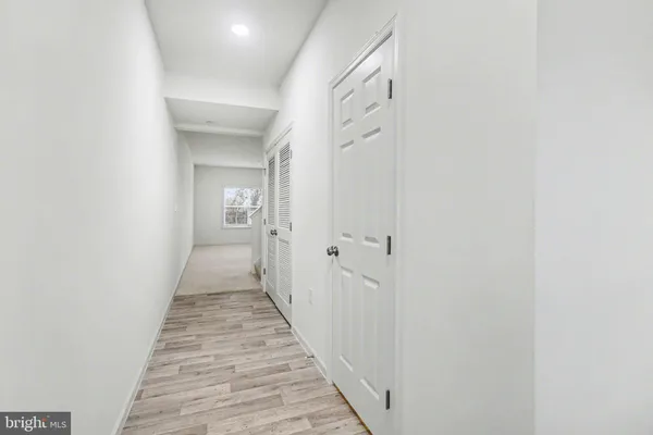 a view of a hallway with wooden floor