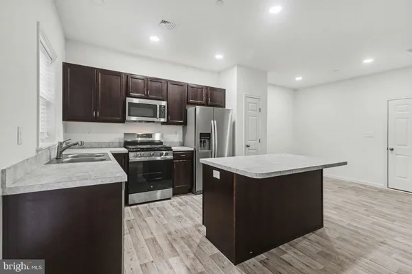 a kitchen with a sink stove and refrigerator
