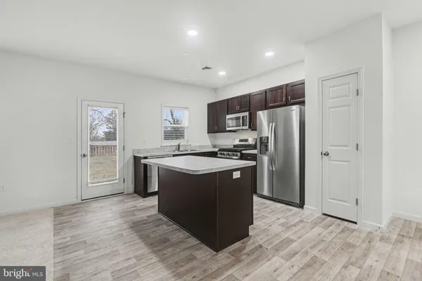 a kitchen with stainless steel appliances granite countertop a refrigerator and a stove top oven