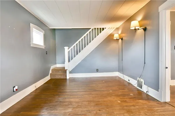 a view of a big room with wooden floor and windows