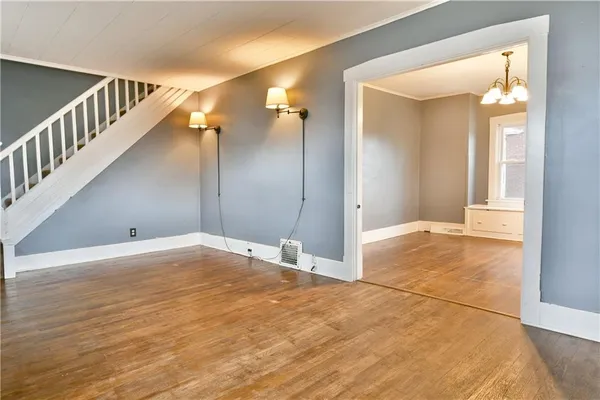 a view of a big room with wooden floor and windows