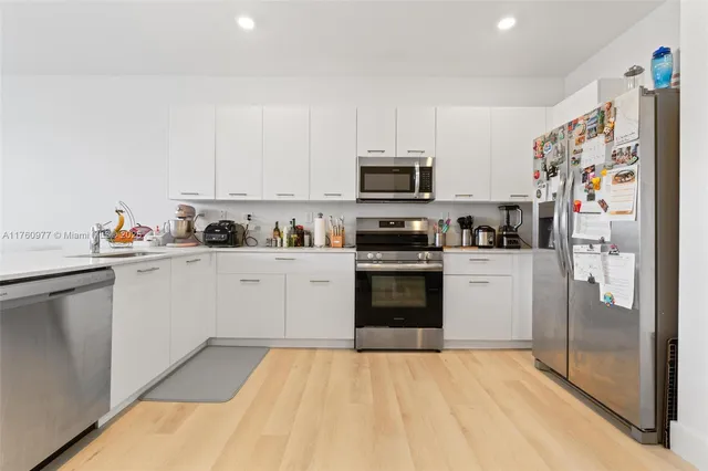 a kitchen with stainless steel appliances a refrigerator sink and microwave