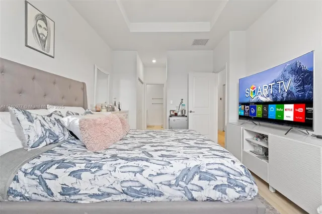 a large bedroom with a bed and a flat screen tv