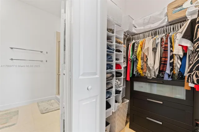 a view of walk in closet with clothes