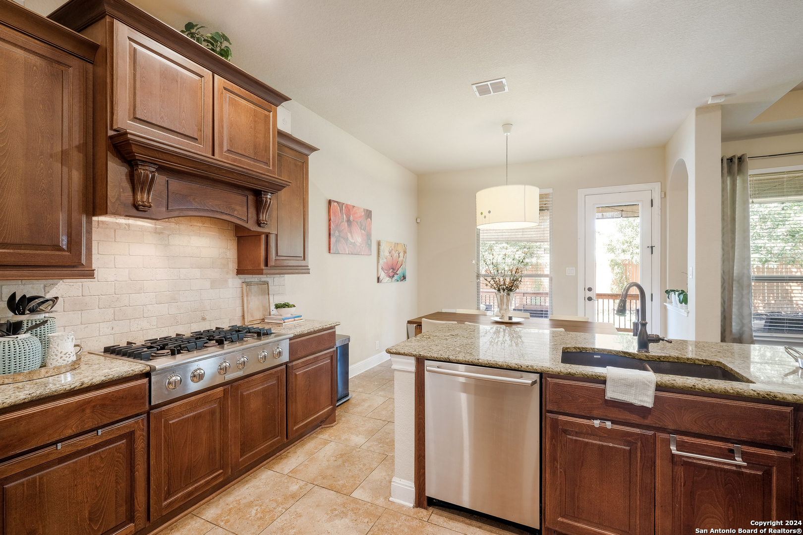 24503 Merlot Way San Antonio, TX 78260 - Photo 11 of 26 a kitchen with granite countertop stainless steel appliances a sink stove and cabinets