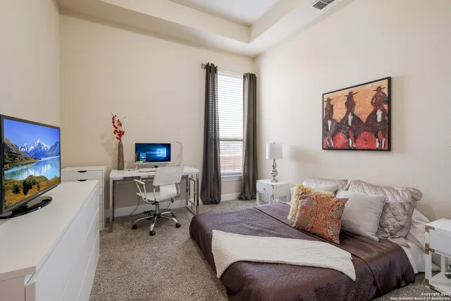 a bedroom with a bed a couch and a flat screen tv