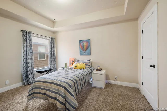 a bedroom with a bed and painting on the wall