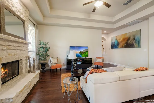 a living room with furniture a fireplace and a chandelier