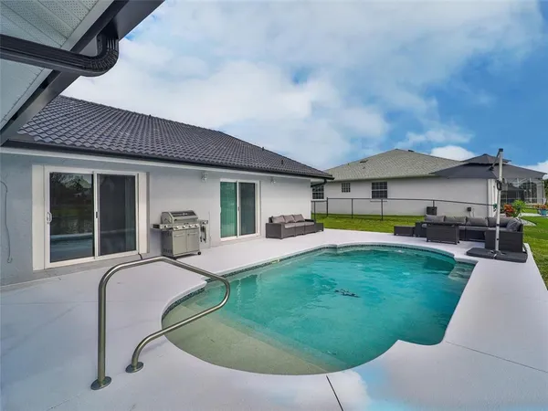 a swimming pool with outdoor seating yard and barbeque oven