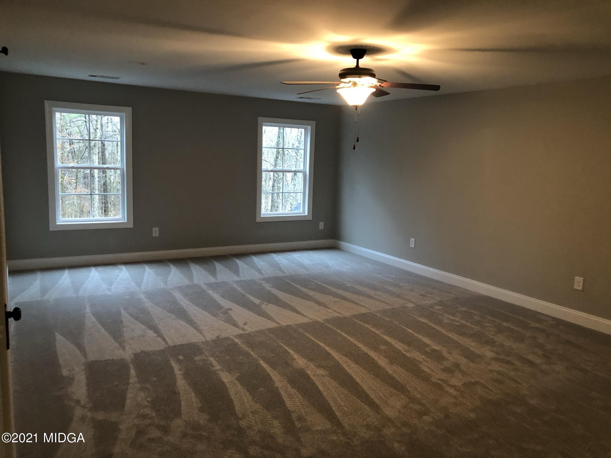85 Adam Drive Forsyth, GA 31029 - Photo 11 of 18 en empty room with windows and chandelier fan