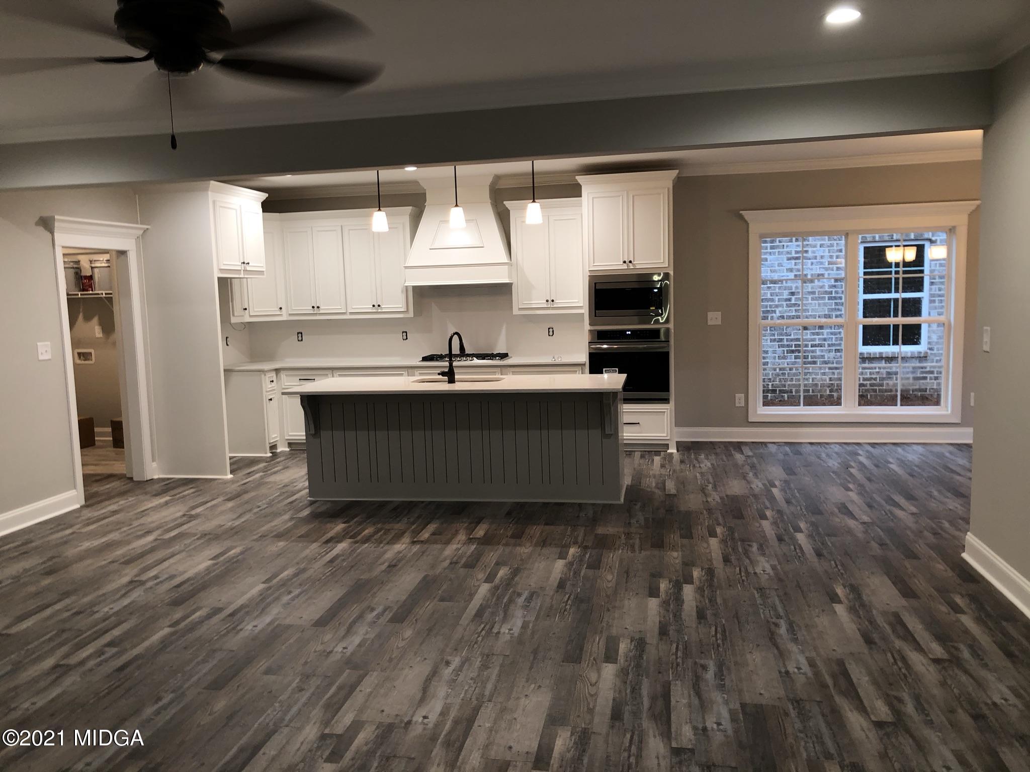 85 Adam Drive Forsyth, GA 31029 - Photo 4 of 18 a living room with stainless steel appliances kitchen island granite countertop a sink and cabinets