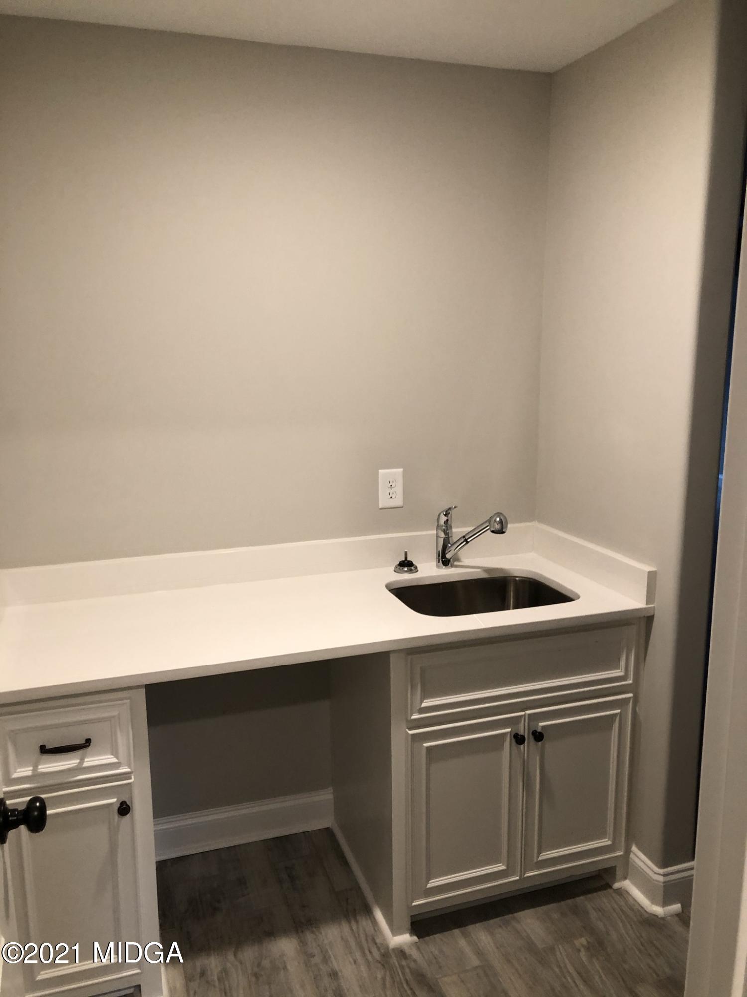 85 Adam Drive Forsyth, GA 31029 - Photo 10 of 18 a utility room with stainless steel appliances a sink dishwasher a stove and white cabinets