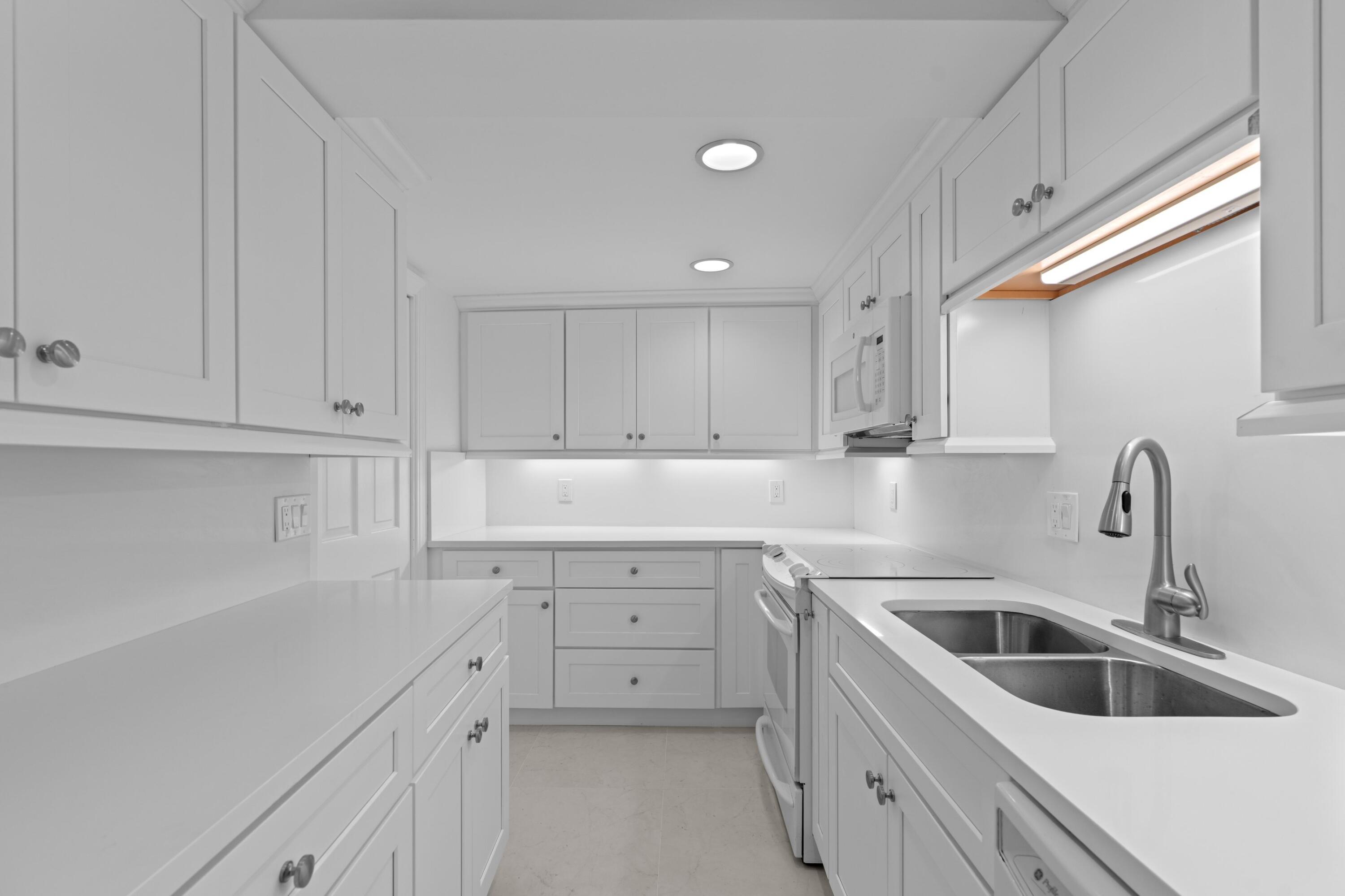 369 South Lake Drive, Unit 1D Palm Beach, FL 33480 - Photo 13 of 46 a kitchen with white cabinets sink and dishwasher