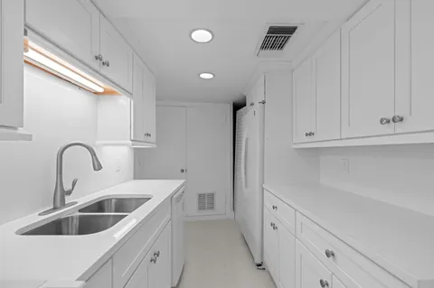 a kitchen with white cabinets and a sink