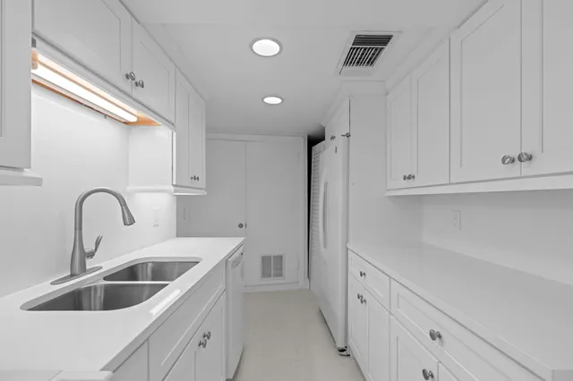 a kitchen with white cabinets and a sink