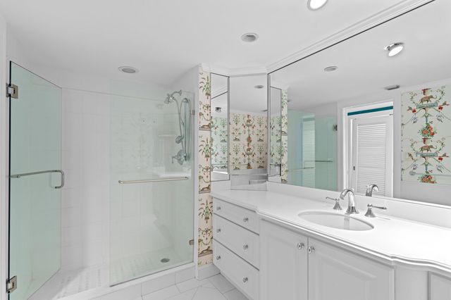 a bathroom with a shower sink vanity granite and shower