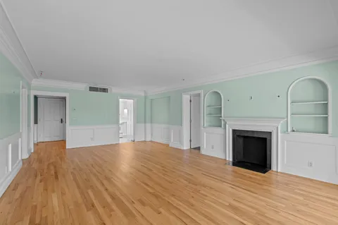 a view of empty room with wooden floor and fireplace