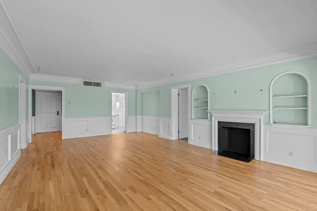 a view of empty room with wooden floor and fireplace