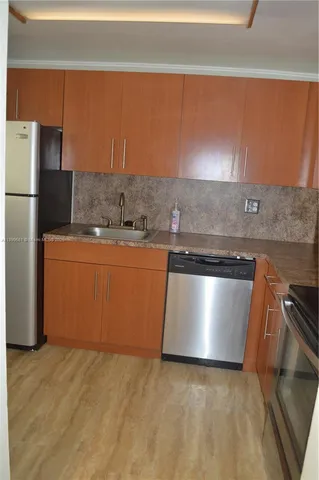 a kitchen with a stove top oven and refrigerator