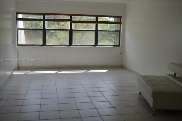 a view of a livingroom with an empty space and a window