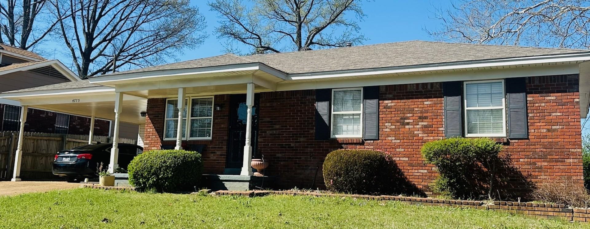 4775 Stacey Road Memphis, TN 38109 - Photo 2 of 13 View of front facade with brick siding, an attached carport, a porch, and concrete driveway